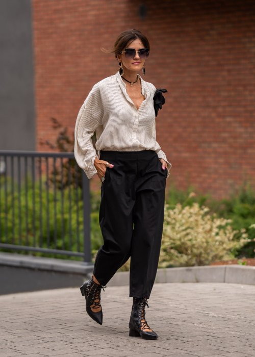 Czarne spodnie damskie typu cygaretki z elastycznym pasem i zwężaną nogawką, zestawione z botkami w eleganckiej miejskiej stylizacji.