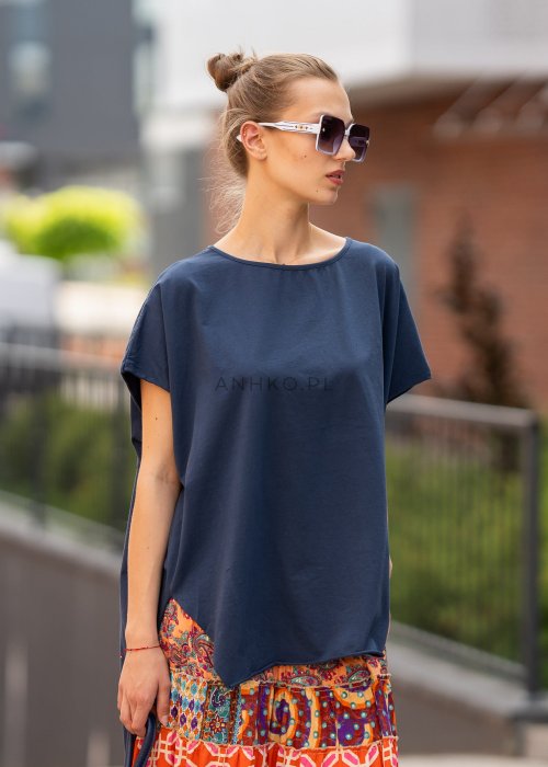 Granatowa bluzka oversize z asymetrycznym dołem i wydłużonym tyłem, zestawiona ze wzorzystą spódnicą. Luźny fason tworzy nowoczesną, miejską stylizację.