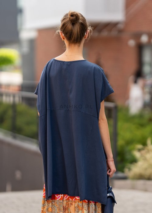 Granatowa bluzka oversize z asymetrycznym dołem i wydłużonym tyłem, zestawiona ze wzorzystą spódnicą. Luźny fason tworzy nowoczesną, miejską stylizację.