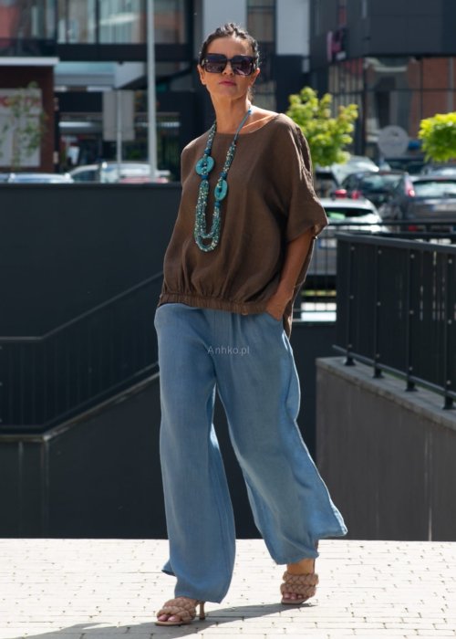 Brązowa bluzka lniana oversize z krótkim rękawem i ściągaczem na dole, stylizowana z szerokimi spodniami i biżuterią w miejskim stylu.