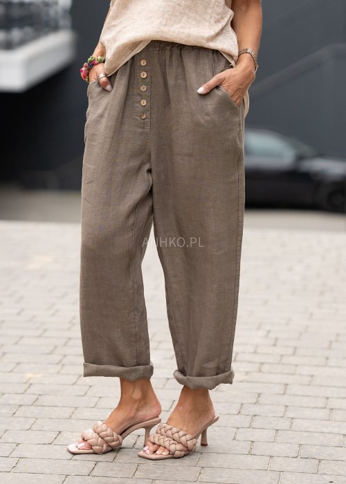 Lniane spodnie damskie taupe z ozdobnymi guzikami z przodu i gumą w pasie, model z kieszeniami po bokach w naturalnej, miejskiej stylizacji.