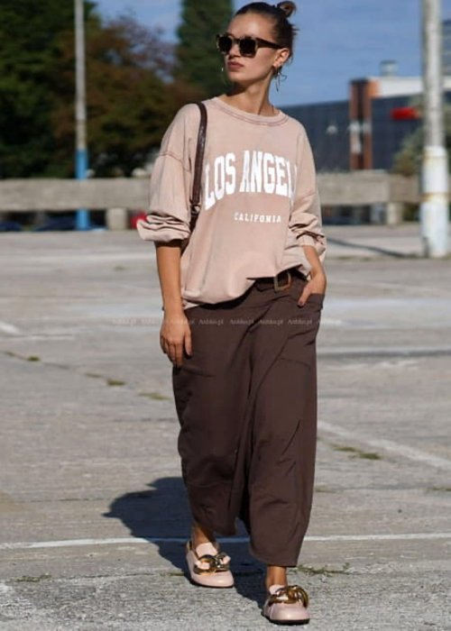 Brązowe spódnico-spodnie damskie o szerokim kroju z wysokim stanem i dużymi kieszeniami, stylizowane z luźną bluzą i mokasynami w miejskim looku.