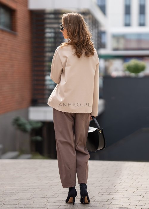 Eleganckie spodnie damskie typu cygaretki w kolorze taupe z elastycznym pasem i zwężaną nogawką, zestawione z botkami na obcasie w miejskiej stylizacji.