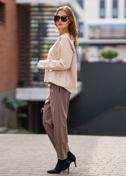 Eleganckie spodnie damskie typu cygaretki w kolorze taupe z elastycznym pasem i zwężaną nogawką, zestawione z botkami na obcasie w miejskiej stylizacji.