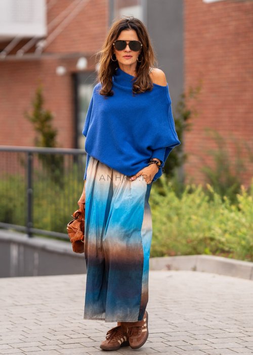 Chabrowy sweter damski oversize o nietoperzowym kroju z dekoltem łódka, luźna stylizacja miejska z plisowaną spódnicą.