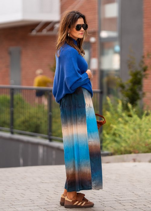 Chabrowy sweter damski oversize o nietoperzowym kroju z dekoltem łódka, luźna stylizacja miejska z plisowaną spódnicą.