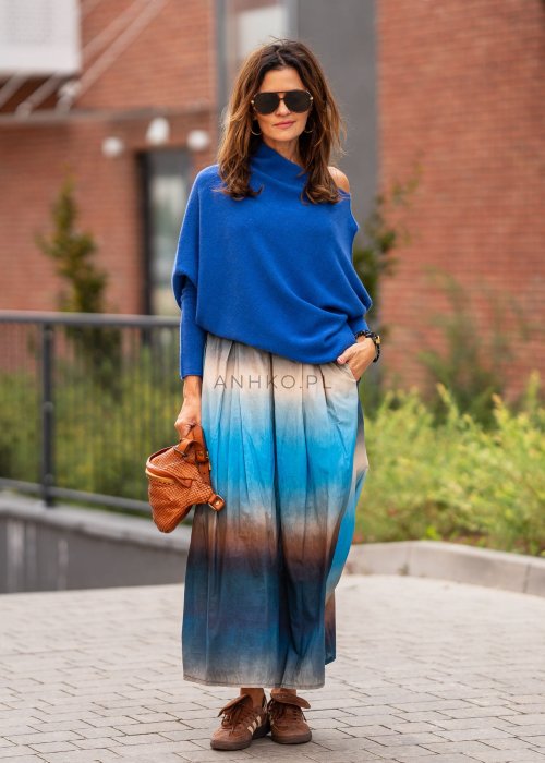 Chabrowy sweter damski oversize o nietoperzowym kroju z dekoltem łódka, luźna stylizacja miejska z plisowaną spódnicą.