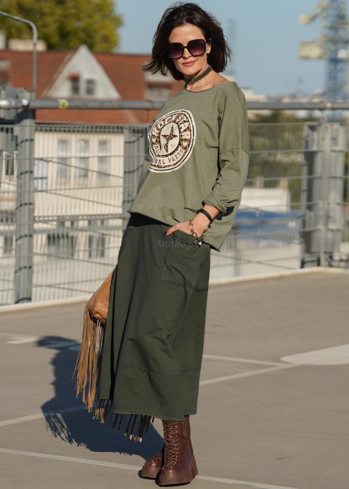 Spódnico-spodnie khaki o długości midi z kieszeniami i elastycznym pasem, stylizowane z botkami i luźną bluzką w miejskim looku.
