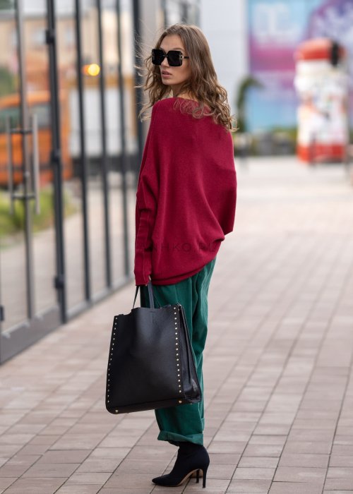 Bordowy sweter oversize o nietoperzowym kroju z dekoltem łódka i asymetrycznym dołem, stylizacja miejska.