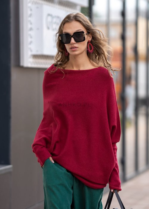 Bordowy sweter oversize o nietoperzowym kroju z dekoltem łódka i asymetrycznym dołem, stylizacja miejska.