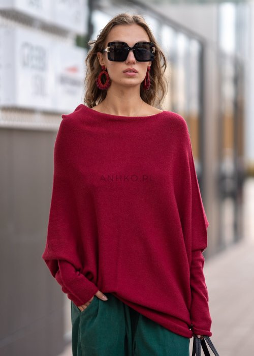 Bordowy sweter oversize o nietoperzowym kroju z dekoltem łódka i asymetrycznym dołem, stylizacja miejska.