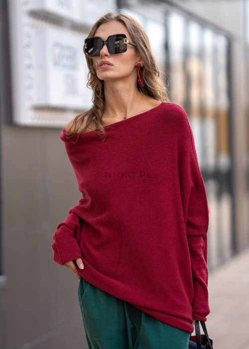 Bordowy sweter oversize o nietoperzowym kroju z dekoltem łódka i asymetrycznym dołem, stylizacja miejska.