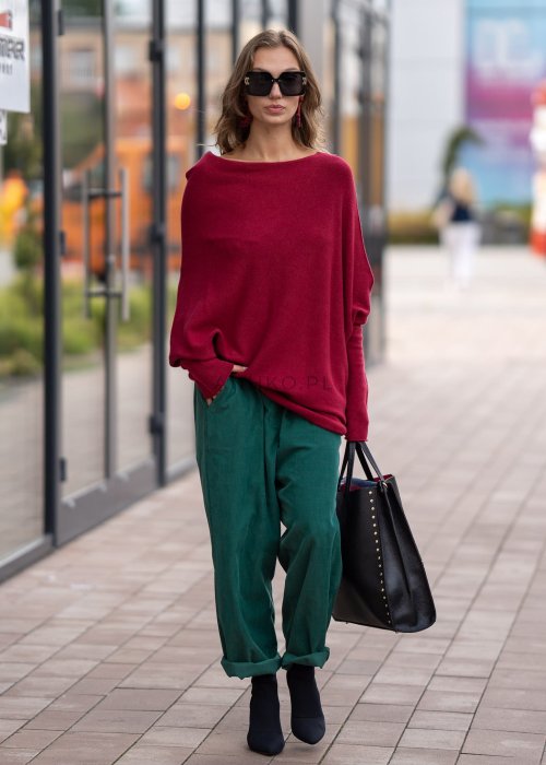 Bordowy sweter oversize o nietoperzowym kroju z dekoltem łódka i asymetrycznym dołem, stylizacja miejska.