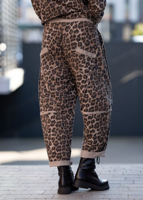 Spodnie damskie w panterkę o kroju oversize z ozdobnymi przeszyciami i elastycznym pasem. Stylizacja z czarnymi botkami w miejskim stylu.