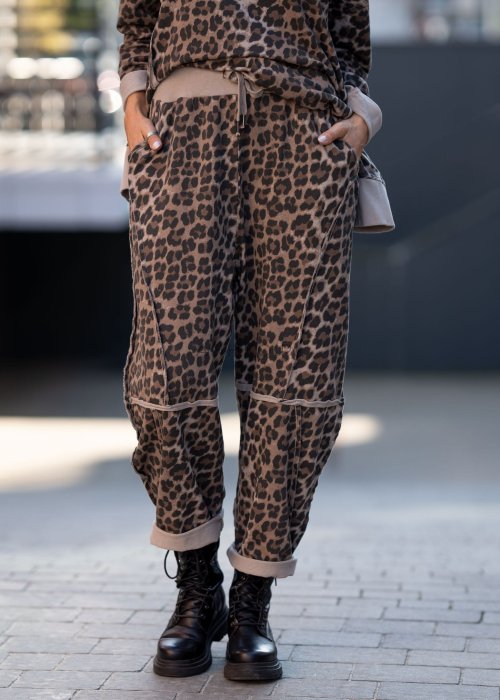 Spodnie damskie w panterkę o kroju oversize z ozdobnymi przeszyciami i elastycznym pasem. Stylizacja z czarnymi botkami w miejskim stylu.