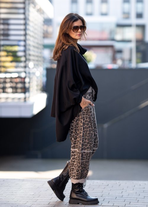 Spodnie damskie w panterkę o kroju oversize z ozdobnymi przeszyciami i elastycznym pasem. Stylizacja z czarnymi botkami w miejskim stylu.