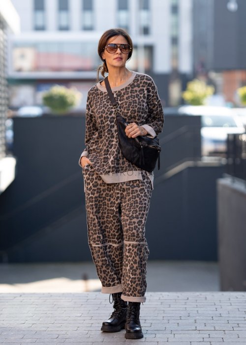 Spodnie damskie w panterkę o kroju oversize z ozdobnymi przeszyciami i elastycznym pasem. Stylizacja z czarnymi botkami w miejskim stylu.