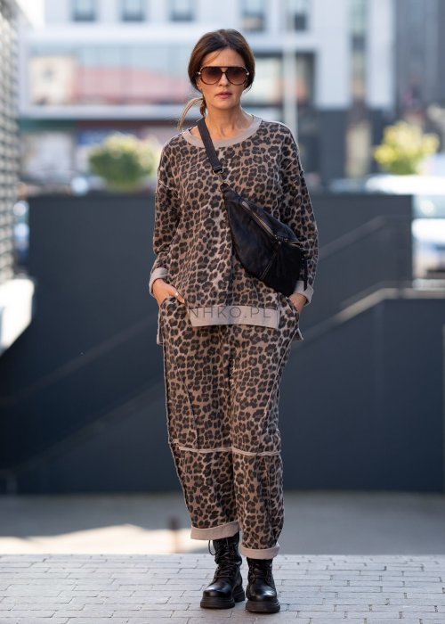 Spodnie damskie w panterkę o kroju oversize z ozdobnymi przeszyciami i elastycznym pasem. Stylizacja z czarnymi botkami w miejskim stylu.