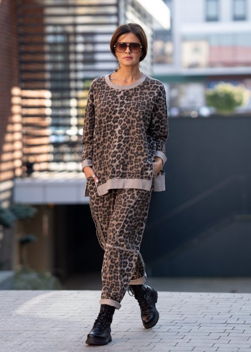 Spodnie damskie w panterkę o kroju oversize z ozdobnymi przeszyciami i elastycznym pasem. Stylizacja z czarnymi botkami w miejskim stylu.