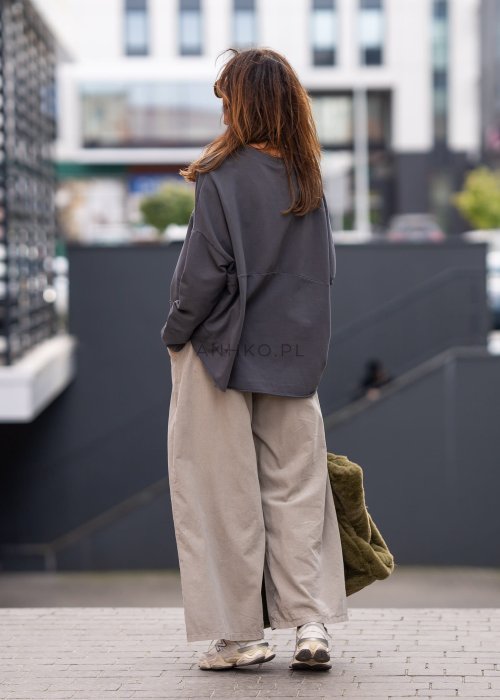Grafitowa bluza damska oversize z długim rękawem i naszywką na froncie. Luźny fason w stylizacji miejskiej z szerokimi spodniami.