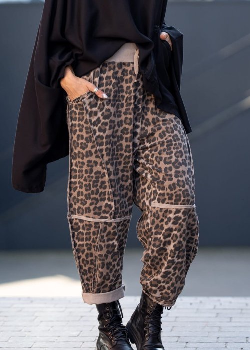 Spodnie damskie w panterkę o kroju oversize z ozdobnymi przeszyciami i elastycznym pasem. Stylizacja z czarnymi botkami w miejskim stylu.