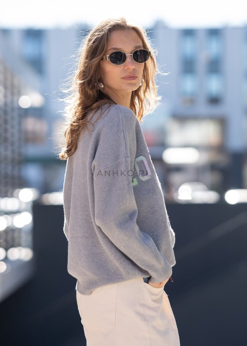 Szary sweter oversize z kolorowym napisem „Los Angeles” w pastelowych odcieniach. Miękki dzianinowy materiał, luźny fason i obniżona linia ramion nadają całości casualowego charakteru, idealnego do codziennych i streetwearowych stylizacji.