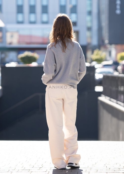 Szary sweter oversize z kolorowym napisem „Los Angeles” w pastelowych odcieniach. Miękki dzianinowy materiał, luźny fason i obniżona linia ramion nadają całości casualowego charakteru, idealnego do codziennych i streetwearowych stylizacji.