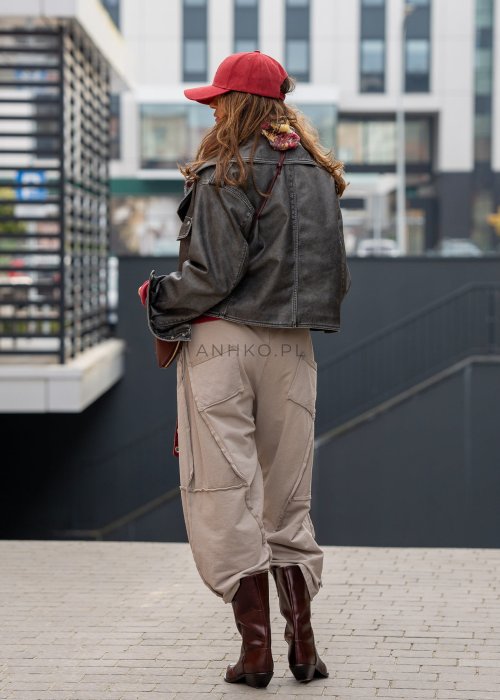 Beżowe spodnie oversize z obniżonym krokiem i dekoracyjnymi przeszyciami, luźny fason, miejska stylizacja damska.