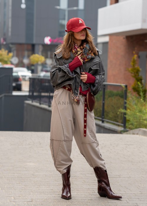 Beżowe spodnie oversize z obniżonym krokiem i dekoracyjnymi przeszyciami, luźny fason, miejska stylizacja damska.