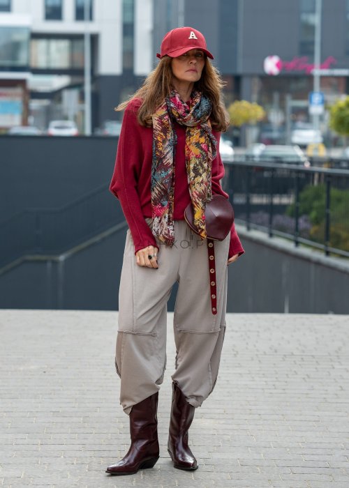 Beżowe spodnie oversize z obniżonym krokiem i dekoracyjnymi przeszyciami, luźny fason, miejska stylizacja damska.