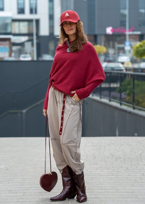 Beżowe spodnie oversize z obniżonym krokiem i dekoracyjnymi przeszyciami, luźny fason, miejska stylizacja damska.