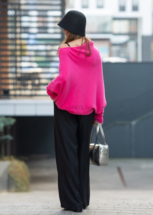 Fuksjowy sweter damski oversize o nietoperzowym kroju z dekoltem łódka, wyrazista stylizacja miejska.