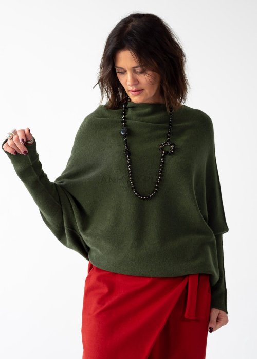 Khaki sweter oversize o nietoperzowym kroju z dekoltem łódka i asymetrycznym dołem zestawiony z czerwonymi szerokimi spodniami i długim naszyjnikiem.