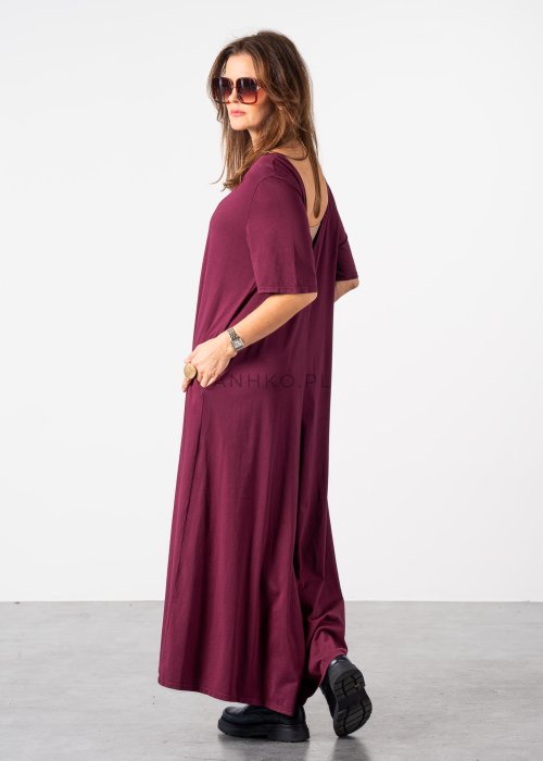 Śliwkowy kombinezon damski oversize z szeroką nogawką i krótkim rękawem, z głębokim wycięciem na plecach w stylizacji z biżuterią i okularami przeciwsłonecznymi.