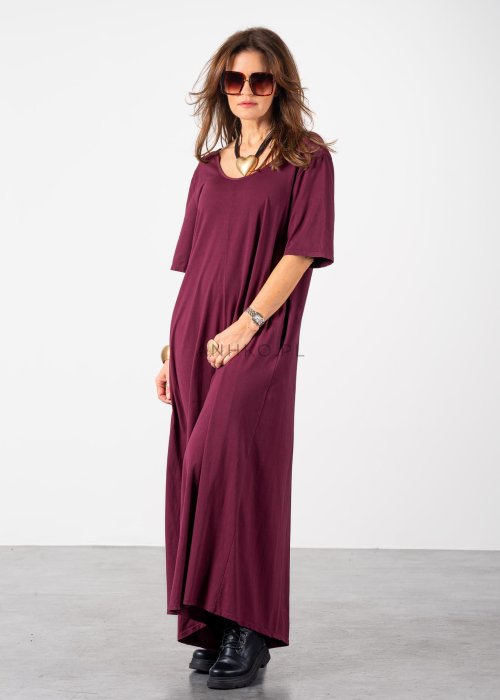 Śliwkowy kombinezon damski oversize z szeroką nogawką i krótkim rękawem, z głębokim wycięciem na plecach w stylizacji z biżuterią i okularami przeciwsłonecznymi.