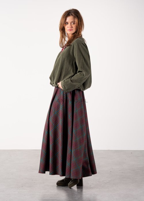 Bluzka damska oversize w kolorze khaki z długim rękawem i regulowanym dołem, stylizacja z rozkloszowaną spódnicą w kratę i botkami.