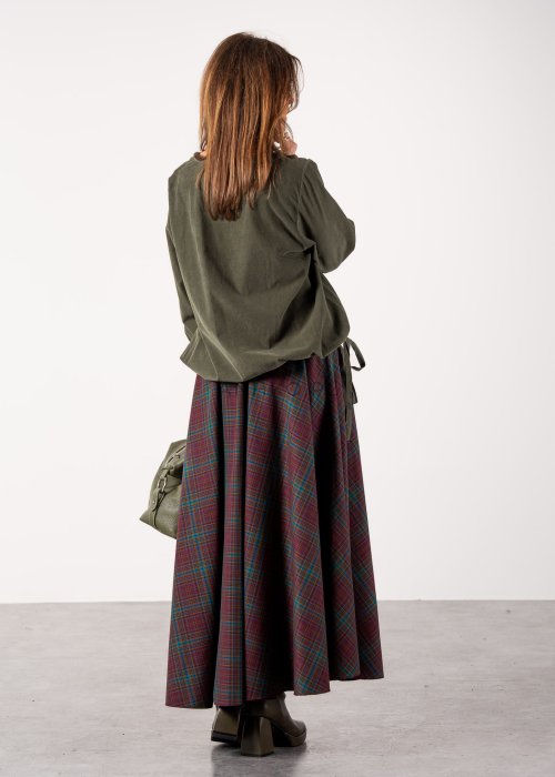 Bluzka damska oversize w kolorze khaki z długim rękawem i regulowanym dołem, stylizacja z rozkloszowaną spódnicą w kratę i botkami.