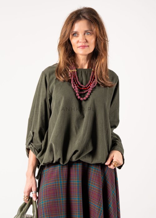 Bluzka damska oversize w kolorze khaki z długim rękawem i regulowanym dołem, stylizacja z rozkloszowaną spódnicą w kratę i botkami.