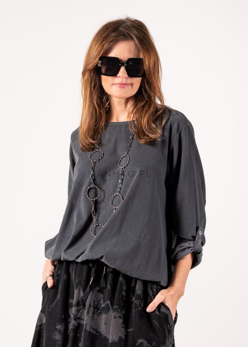 Szara bluzka damska oversize z długim rękawem i regulowanym dołem, minimalistyczny fason w stylizacji z czarną spódnicą midi i botkami.