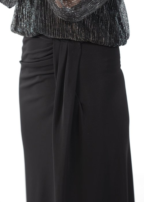 Długa czarna spódnica z lejącą tkaniną, marszczeniem przy biodrze i opadającym panelem materiału z przodu.