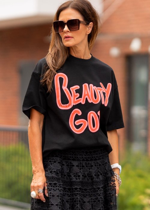 Czarny damski t-shirt oversize z dużym napisem „Beauty God” w różowym kolorze.