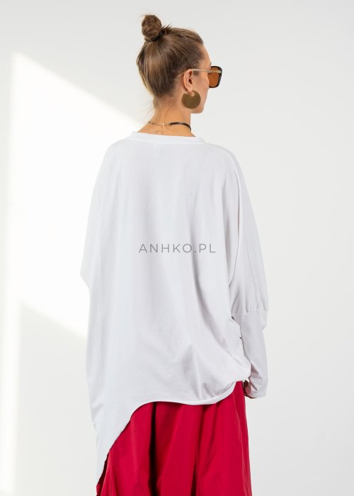 Biała bluzka oversize damska z asymetrycznym dołem i dekoltem V. Stylizacja z czerwonymi spodniami w nowoczesnym, minimalistycznym stylu.