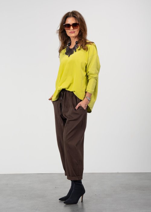 Brązowe spodnie damskie RelaxFit z elastycznym pasem i podwiniętymi nogawkami, stylizowane z białą koszulą oversize i botkami na obcasie w miejskim looku.