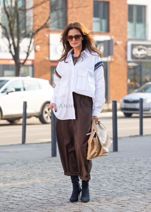 Brązowe spodnie damskie RelaxFit z elastycznym pasem i podwiniętymi nogawkami, stylizowane z białą koszulą oversize i botkami na obcasie w miejskim looku.