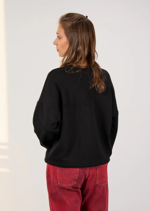 Bluza damska w czarnym kolorze, o luźnym fasonie oversize z długimi rękawami i dekoracyjnym motywem serca z napisem oraz kolorowymi sznurkami.