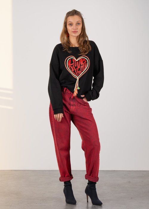Bluza damska w czarnym kolorze, o luźnym fasonie oversize z długimi rękawami i dekoracyjnym motywem serca z napisem oraz kolorowymi sznurkami.