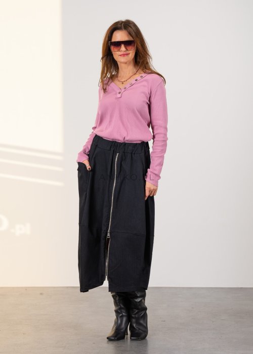 Grafitowa spódnica midi z asymetrycznym dołem i długim zamkiem z przodu, z elastyczną talią i kieszeniami. Model pokazany w stylizacji z dopasowaną bluzką i czarnymi kozakami na obcasie.