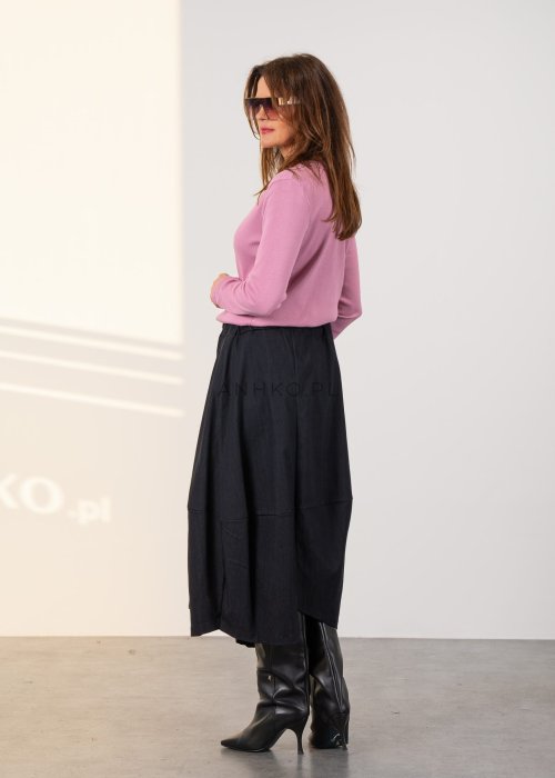 Grafitowa spódnica midi z asymetrycznym dołem i długim zamkiem z przodu, z elastyczną talią i kieszeniami. Model pokazany w stylizacji z dopasowaną bluzką i czarnymi kozakami na obcasie.