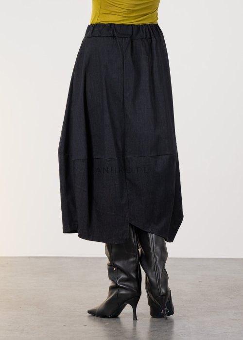 Grafitowa spódnica midi z asymetrycznym dołem i długim zamkiem z przodu, z elastyczną talią i kieszeniami. Model pokazany w stylizacji z dopasowaną bluzką i czarnymi kozakami na obcasie.