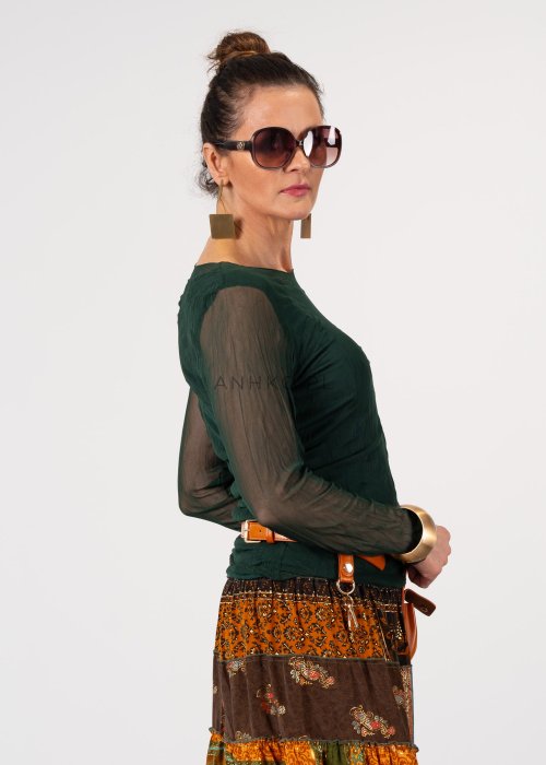 Ciemnozielona bluzka damska z transparentnymi rękawami i dekoltem łódka, elegancka stylizacja z paskiem i wzorzystą spódnicą.